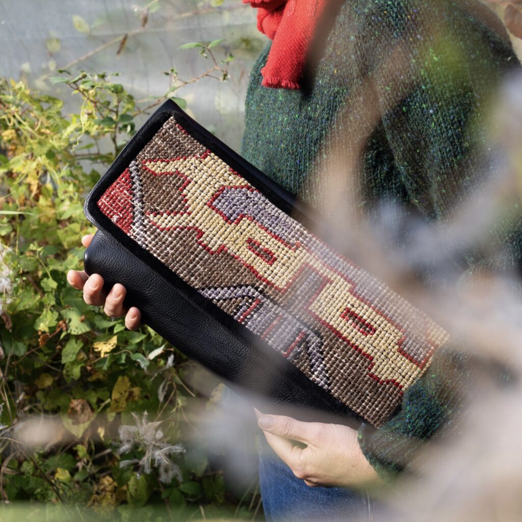 Black Leather Clutch with Vintage Turkish Rug Black leather clutch bag featuring a vintage Turkish rug.