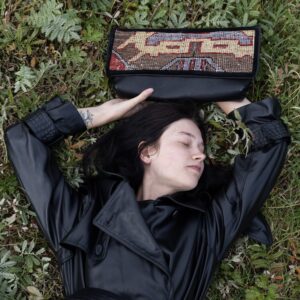 Black leather clutch bag featuring a colourful vintage Turkish rug fragment.